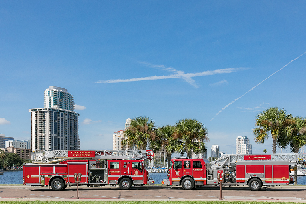 2 fire trucks facing each other in front of waterfront